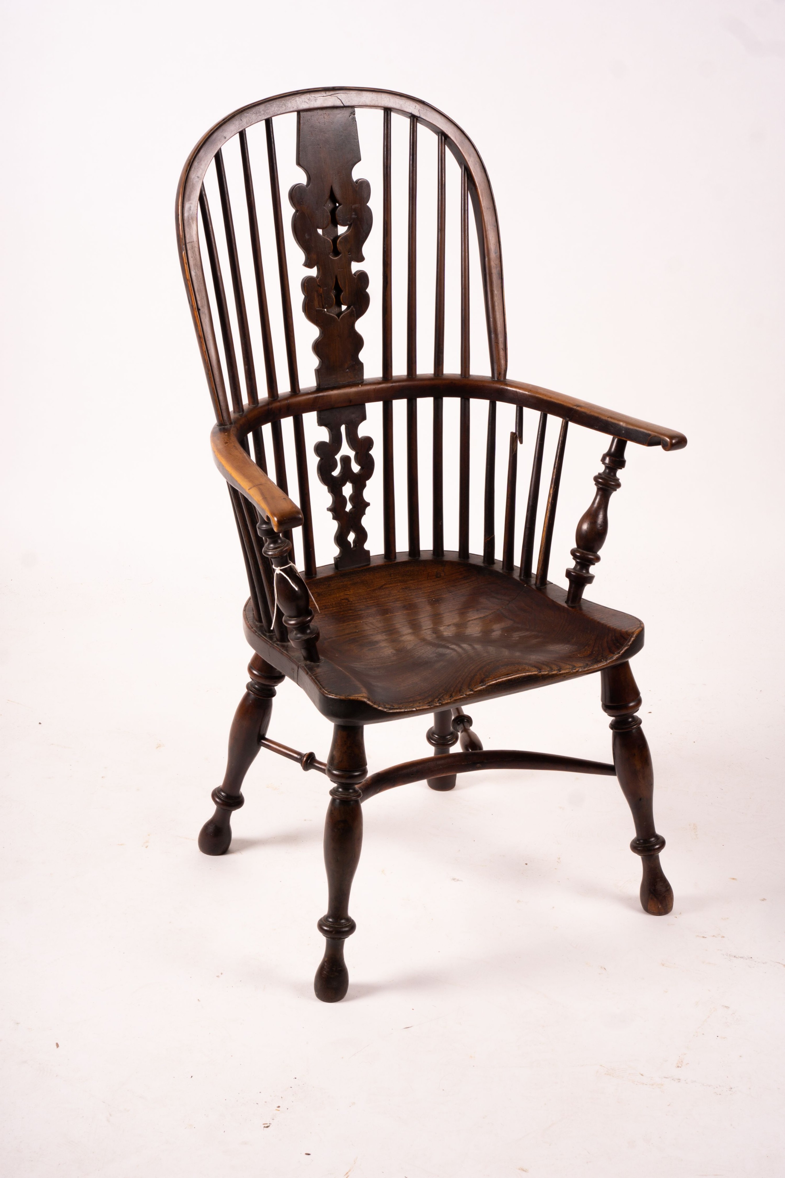 A mid 19th century yew and elm Yorkshire area Windsor armchair with saddle-seat and crinoline stretcher, width 63cm, depth 47cm, height 110cm